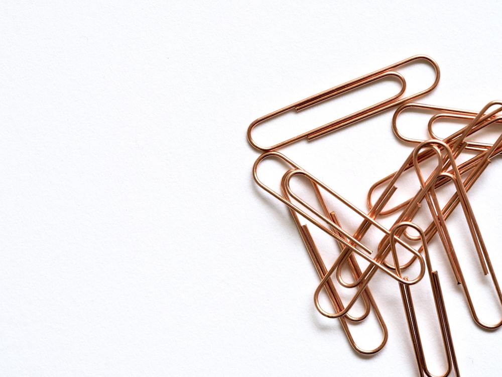 A pile of copper colored paperclips