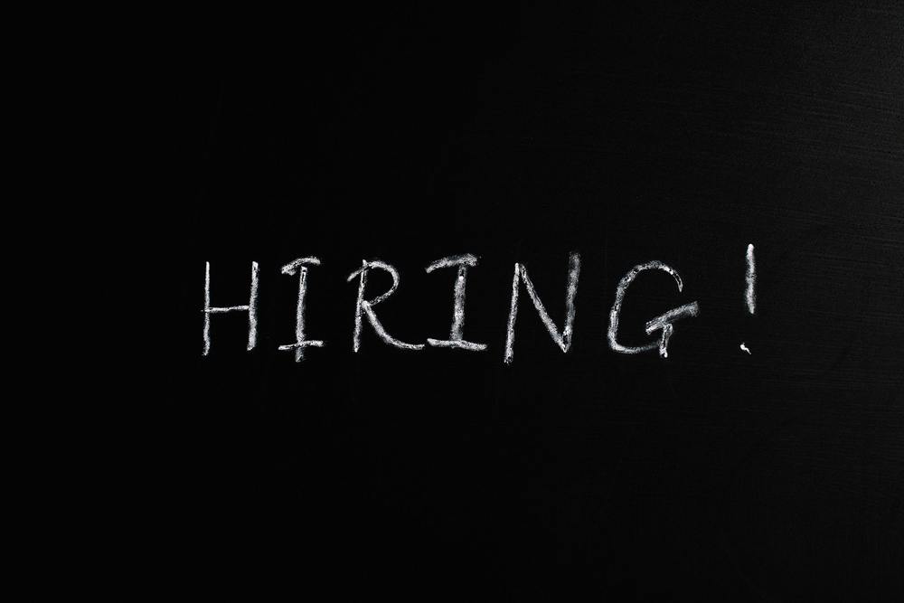 Writing on a chalkboard that says hiring.