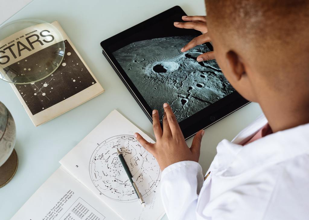 Student looking at a tablet image of the moon